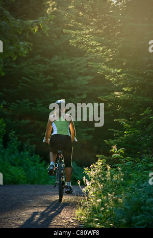 Mapleton park, moncton, new brunswick with woman bicycling into the setting sun Stock Photo