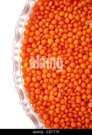 red lentils in a glass plate isolated on white background Stock Photo