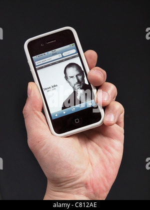 Apple homepage with Steve Jobs in memoriam on the day he died, shown on an iPhone 4 in hand. Stock Photo
