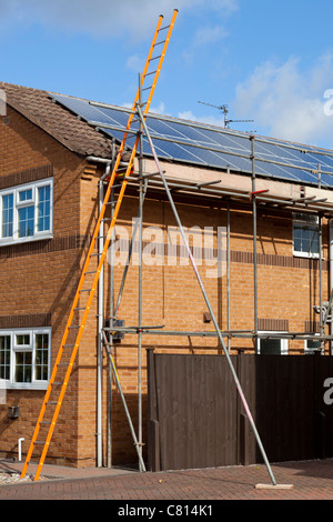 solar panels being fitted on a detached house roof england uk gb europe solar panels on roof uk solar panel installation Stock Photo