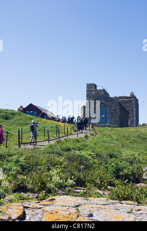 Visitors arriving on Inner Farne, St. Cuthbert's Chapel in background, Farne Islands, Northumberland Coast, England. Stock Photo