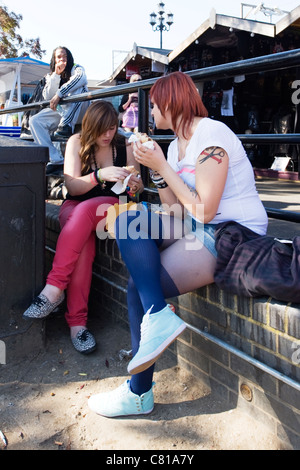 London Camden Town Lock Stables Village market young girls women ladies females with tattoos eating hamburgers by canal Stock Photo