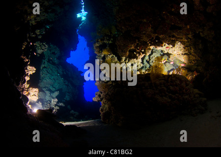 Cave in the Red Sea underwater, cavern, sun beams, coral reef, blue water, dark, scuba, diving, grotto, tropical reef, sun beams Stock Photo