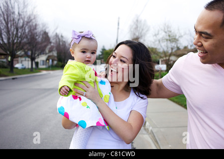 Mother and father standing outdoors with baby girl Stock Photo
