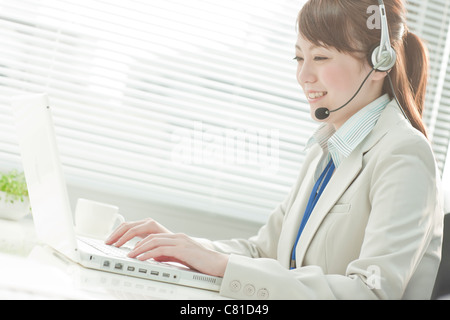 Businesswoman with Laptop Using Headset Stock Photo