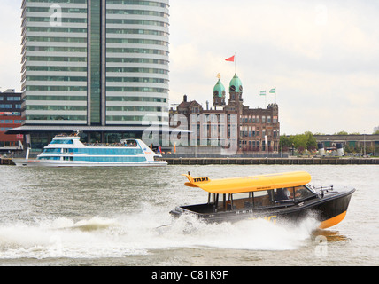 Looking across the Nieuwe Mass to the tower architecture of Kop van Zuid, Rotterdam, Netherlands. A water taxi speeds by. Stock Photo