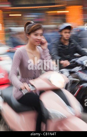Vietnam, Hanoi, Motorbike Traffic, woman on mobile phone Stock Photo