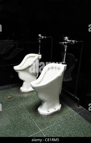 two old urinals in a public mens bathroom Stock Photo