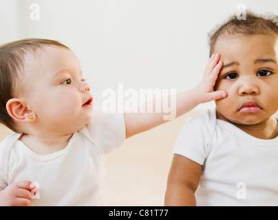 two babies girls playing together with color toys Stock Photo - Alamy