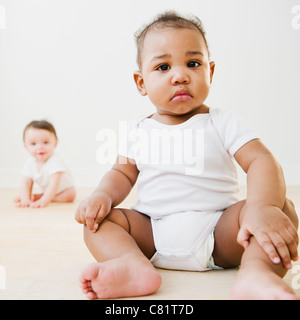 Black baby sitting on floor