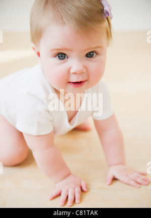 Caucasian baby crawling on floor Stock Photo