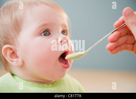 Mother feeding Caucasian baby Stock Photo