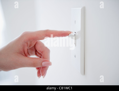 Korean woman turning off light switch Stock Photo