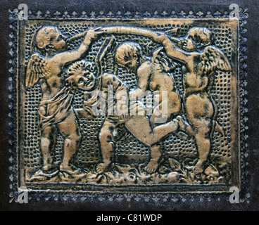 four antique gilded cupids embossed on dark brown leather Stock Photo