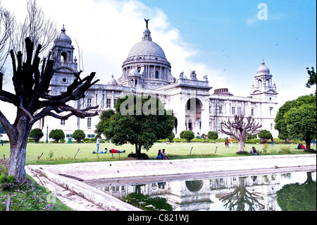 Landscape of Victoria Memorial reflected in the lake water under white clouds and blue sky - in Kolkata-India. Stock Photo