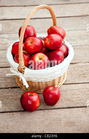 basket of red apples on wood floor aerial view Stock Photo