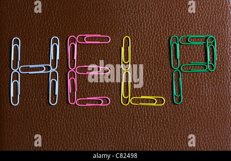 The word 'help' formed with paperclips on a desktop Stock Photo
