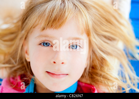 Beautiful blond blue eyes girl lying closeup face Stock Photo
