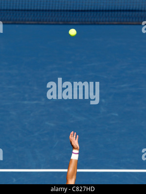 Tennis serve, arm tossing the ball in the air in front of the net at the US Open 2011 tennis tournament Stock Photo