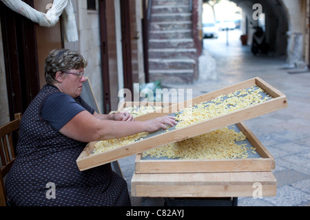 Woman making pasta on the Medieval streets of Bari old town, Puglia Italy. Photo:Jeff Gilbert Stock Photo