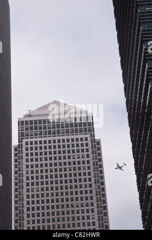 A view of One Canada Square with an airplane on its approach to City Airport behind Canary Wharf skyscrapers. London, UK. Stock Photo