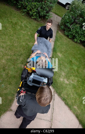 Overhead view of emergency medical team pushing senior woman on stretcher. Shallow DOF sharp focus on patient Stock Photo