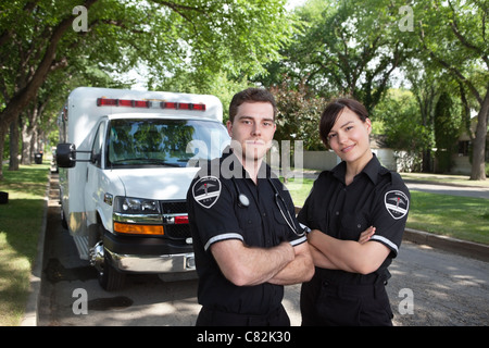 Portrait of two paramedics standing in front of ambulance vehicle Stock Photo