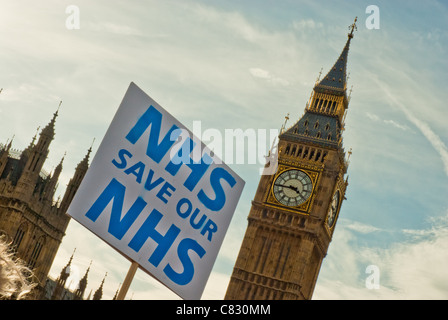 Single placard 'NHS SAVE OUR NHS' against Big Ben both at a jaunty angle. Stock Photo