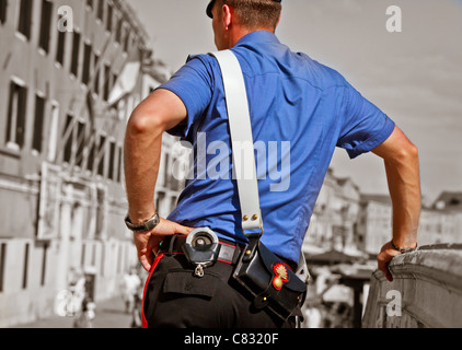 Backside of police officer from Venice standing on a bridge, Venice, Veneto, Italy Stock Photo