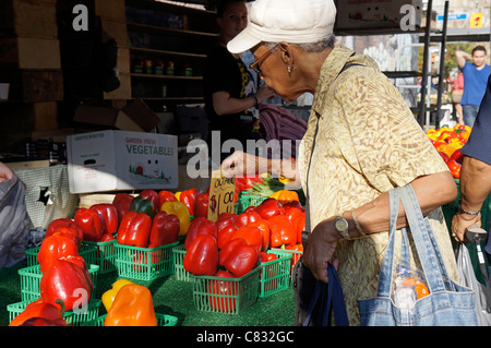Woman Choosing Bell Peppers at outdoor Market Stock Photo