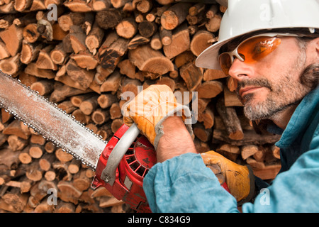 lumberjack close up with chainsaw, forest worker in action Stock Photo