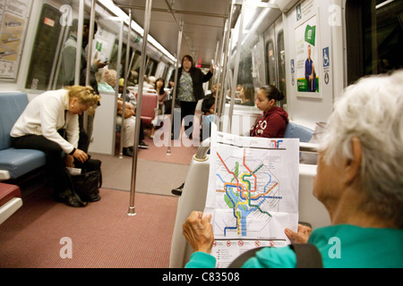 An elderly lady reading a map of the metro subway rail system, Washington DC USA Stock Photo