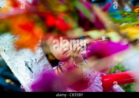 A Salvadoran girl decorates palm fronds with flower blooms during the Flower & Palm Festival in Panchimalco, El Salvador. Stock Photo