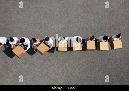 People passing cardboard boxes Stock Photo