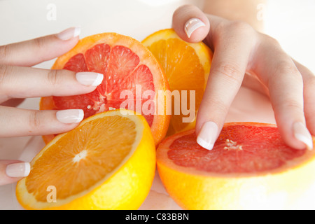 Woman holding halved citrus fruits Stock Photo