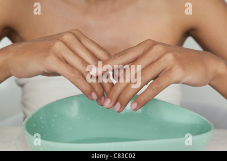 Woman's hands in bowl of water Stock Photo