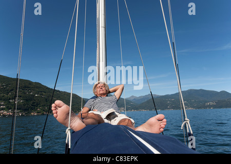 Older man relaxing on sailboat Stock Photo
