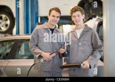 Mechanics working in garage Stock Photo