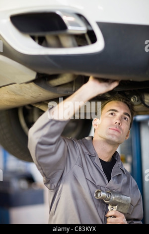 Mechanic working on car in garage Stock Photo
