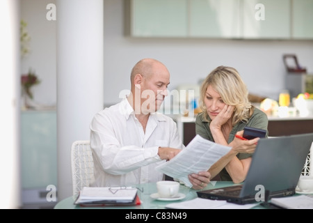 Couple paying their bills at home Stock Photo