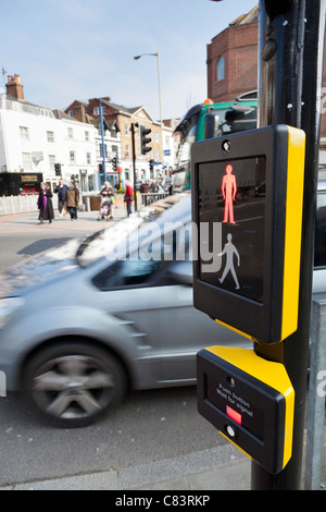 Close-up of pedestrian crossing button and display illuminated red with people  waiting to cross the road, Guildford, England. Stock Photo