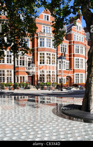 Red brick apartments beyond street water feature 'Silence' by 'Tadao Ando' seen from outside the Connaught Hotel in Mayfair West End London England UK Stock Photo