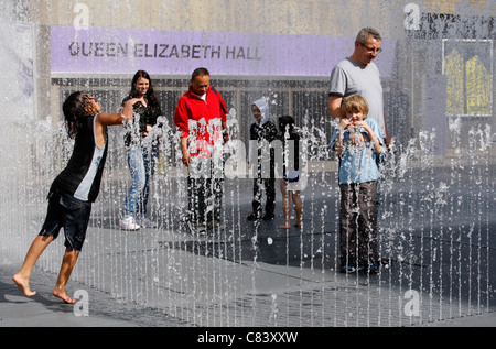 Playing in the Appearing Rooms fountains outside the Queen Elizabeth Hall on London's South Bank Stock Photo
