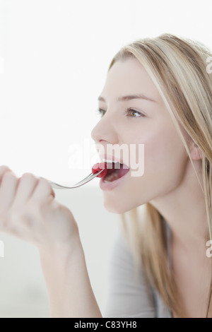 Portrait of a woman biting a raspberry Stock Photo - Alamy