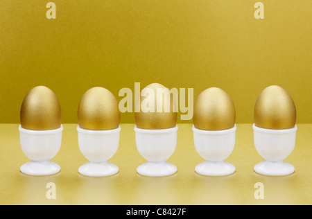 Golden eggs in egg cups Stock Photo