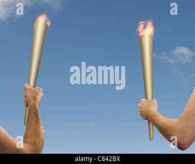 Hands holding flaming batons Stock Photo