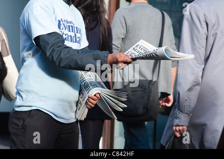 A distributor for the Evening Standard newspaper hands out copies to people. London, 2011 Stock Photo