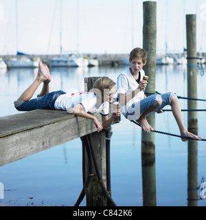 Boys eating ice cream on pier Stock Photo