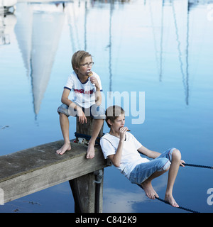 Boys eating ice cream on pier Stock Photo