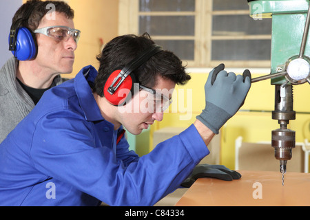 Young man using a bench drill Stock Photo